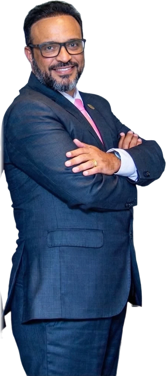 Leandro Lopes Aguilar, de terno azul e gravata rosa, braços cruzados, sorrindo